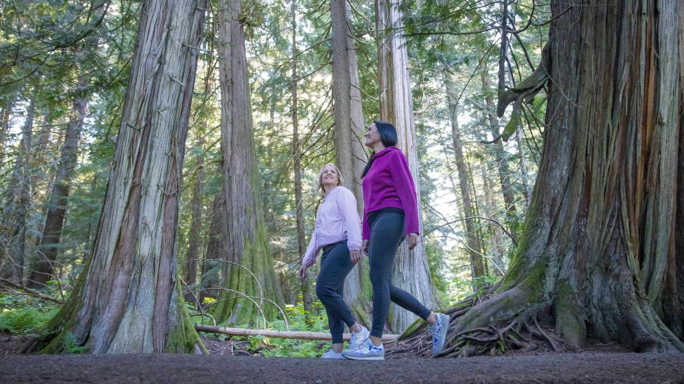 Two women walk to Scandinave Spa Whistler through Lost Lake trails.