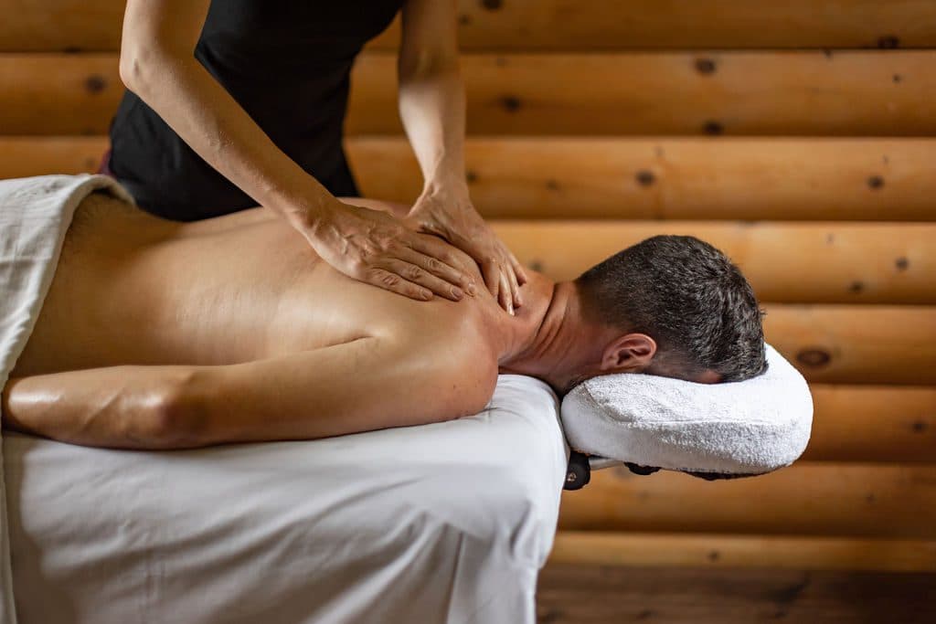 Massage du dos d’un homme allongé sur une table de massage.