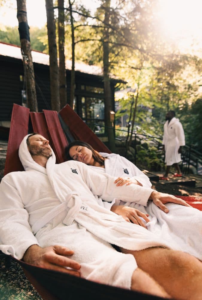 A couple relaxing in a hammock in nature, enjoying the peaceful atmosphere at Scandinave Spa Mont-Tremblant.
