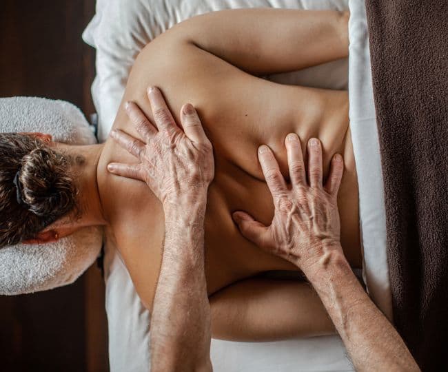 Woman lying face-down receiving a great back massage at Scandinave Spa Mont-Tremblant.