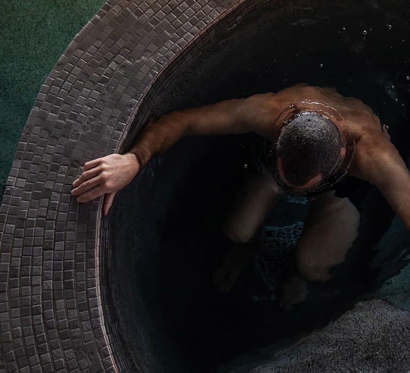 Overhead view of a man immersed in a cold Nordic pool during the thermal journey.