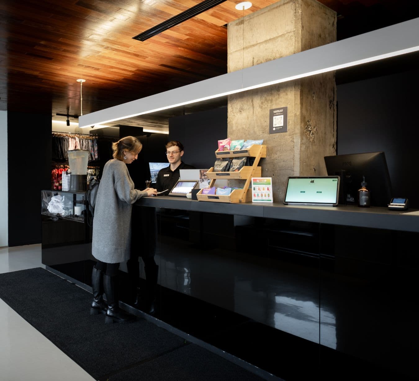 Lobby of the Scandinave Spa Vieux-Montréal, featuring a modern reception desk. An experience combining urban relaxation, thermotherapy, and massages.
