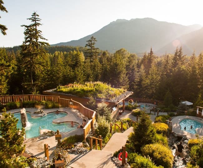Sun dips down over the mountains at Scandinave Spa Whistler in Summer