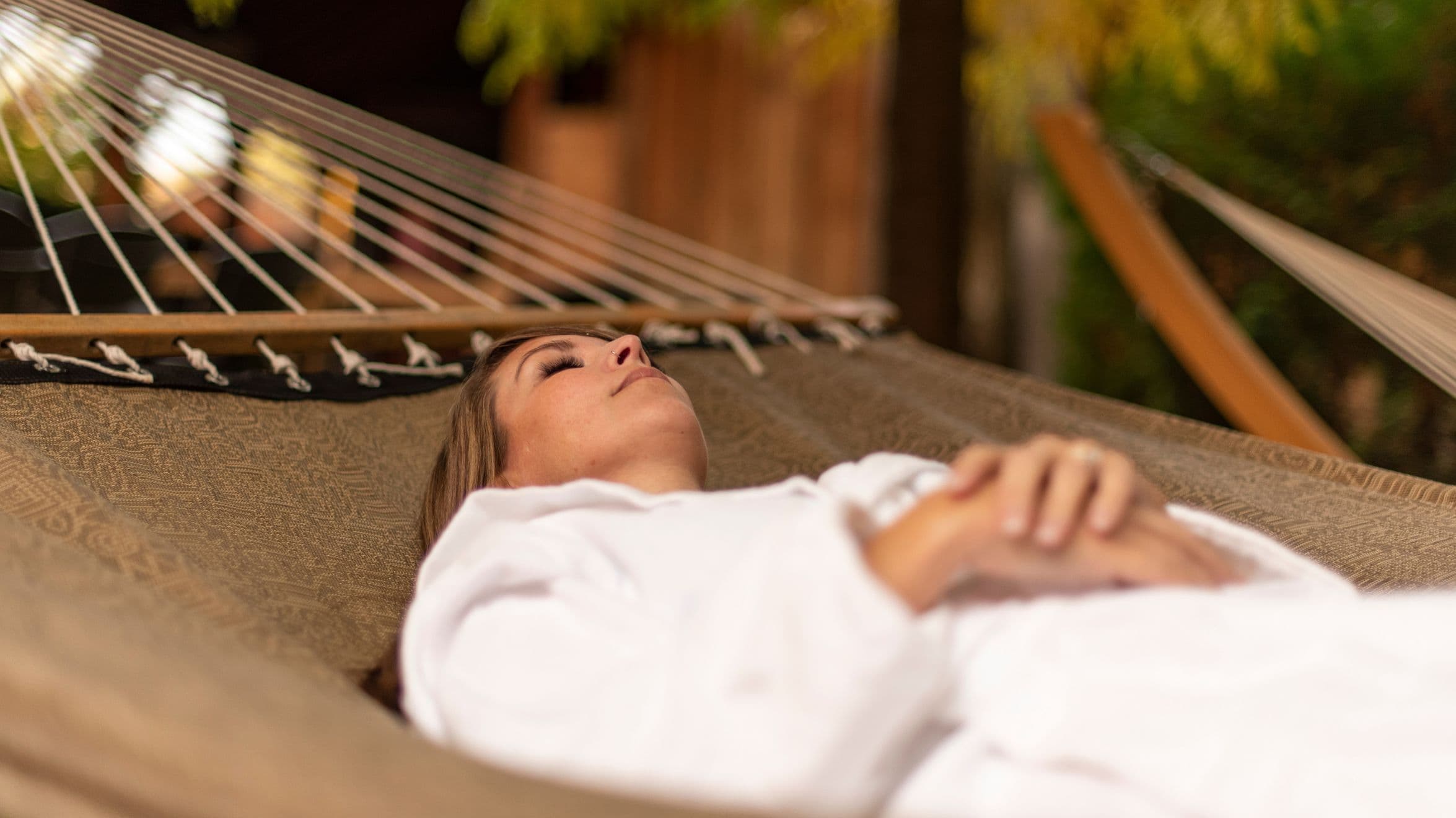 A woman is taking a nap in a hammock at Scandinave Spa Blue Mountain.