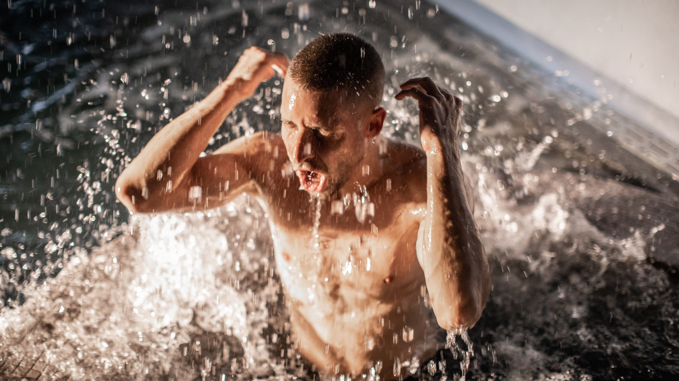 A man enjoying the cold plunge at Scandinave Spa Vieux-Montréal, bathing in the sunrise summer light.