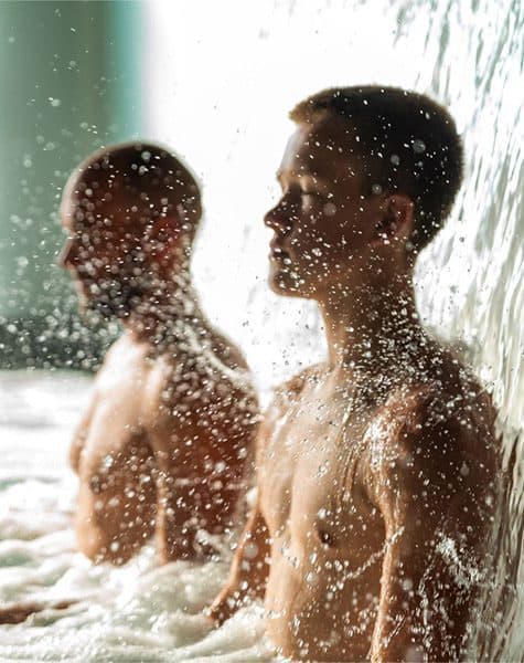 A father and son under the thermal waterfall at Scandinave Spa.