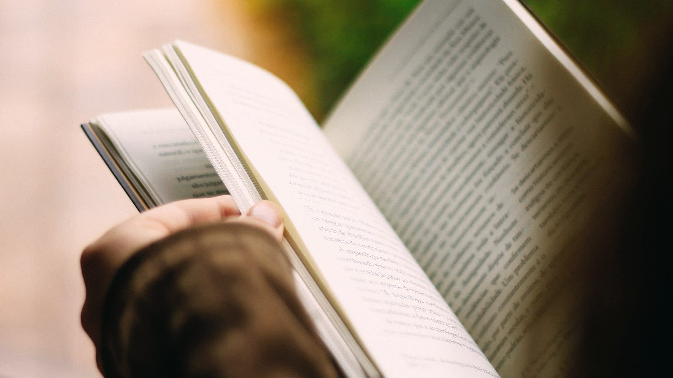 Person holding an inspiring book for screen-free time.