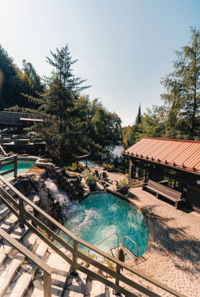Summer view of the Scandinave Spa Mont-Tremblant, surrounded by lush greenery and perfect for disconnection.