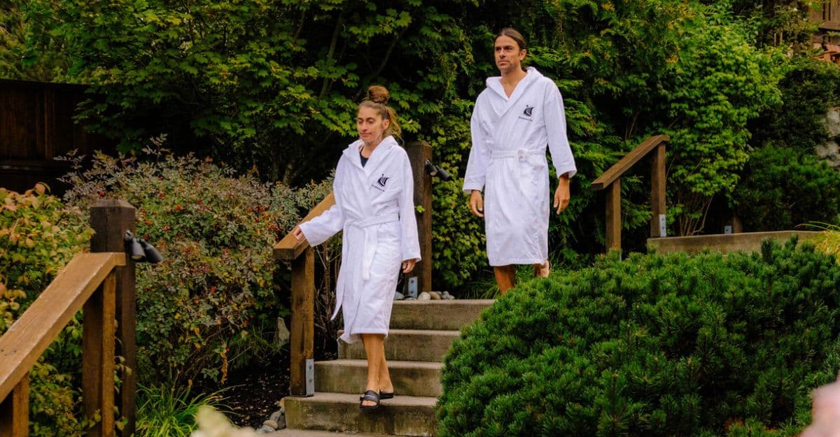 A couple walking through the natural setting of Scandinave Spa Whistler, surrounded by lush forest paths.